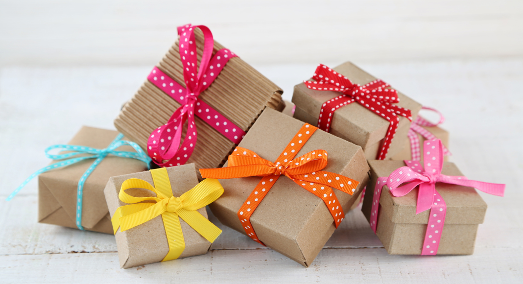 teacher appreciation week gifts: A pile of small boxes wrapped in brown paper and colorful ribbon.