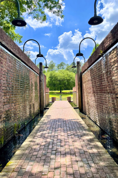 Brick walkway lit by pendant lights at Old Santee Canal Park.