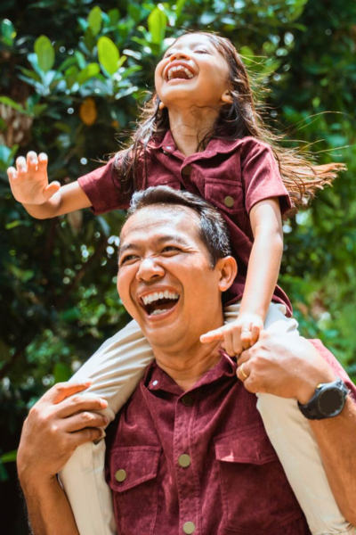 Father's Day Events: a dad gives his young daughter a ride on his shoulders.